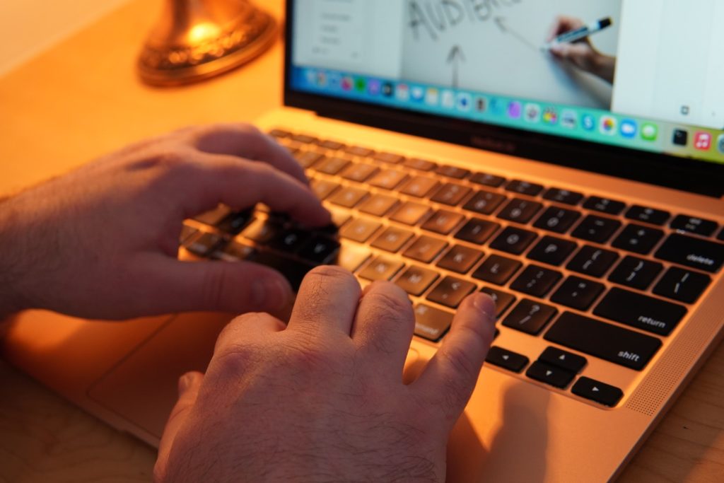 a pair of hands typing on a laptop keyboard