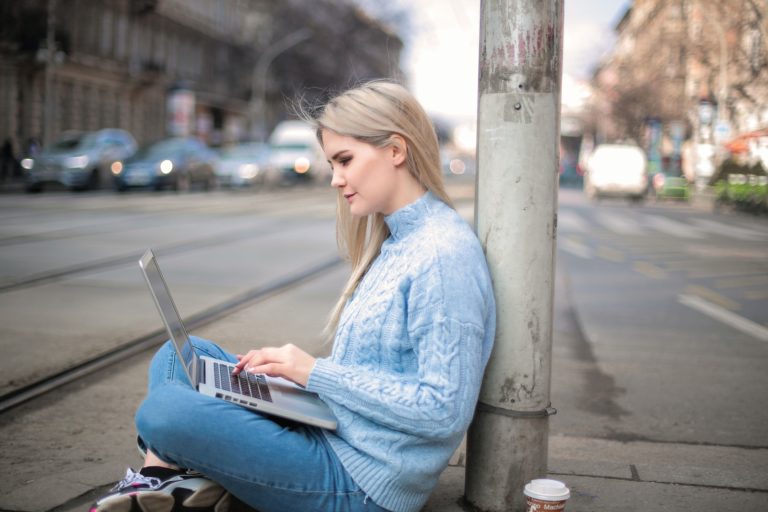 Woman in Blue Long Sleeve Shirt While Using Laptop